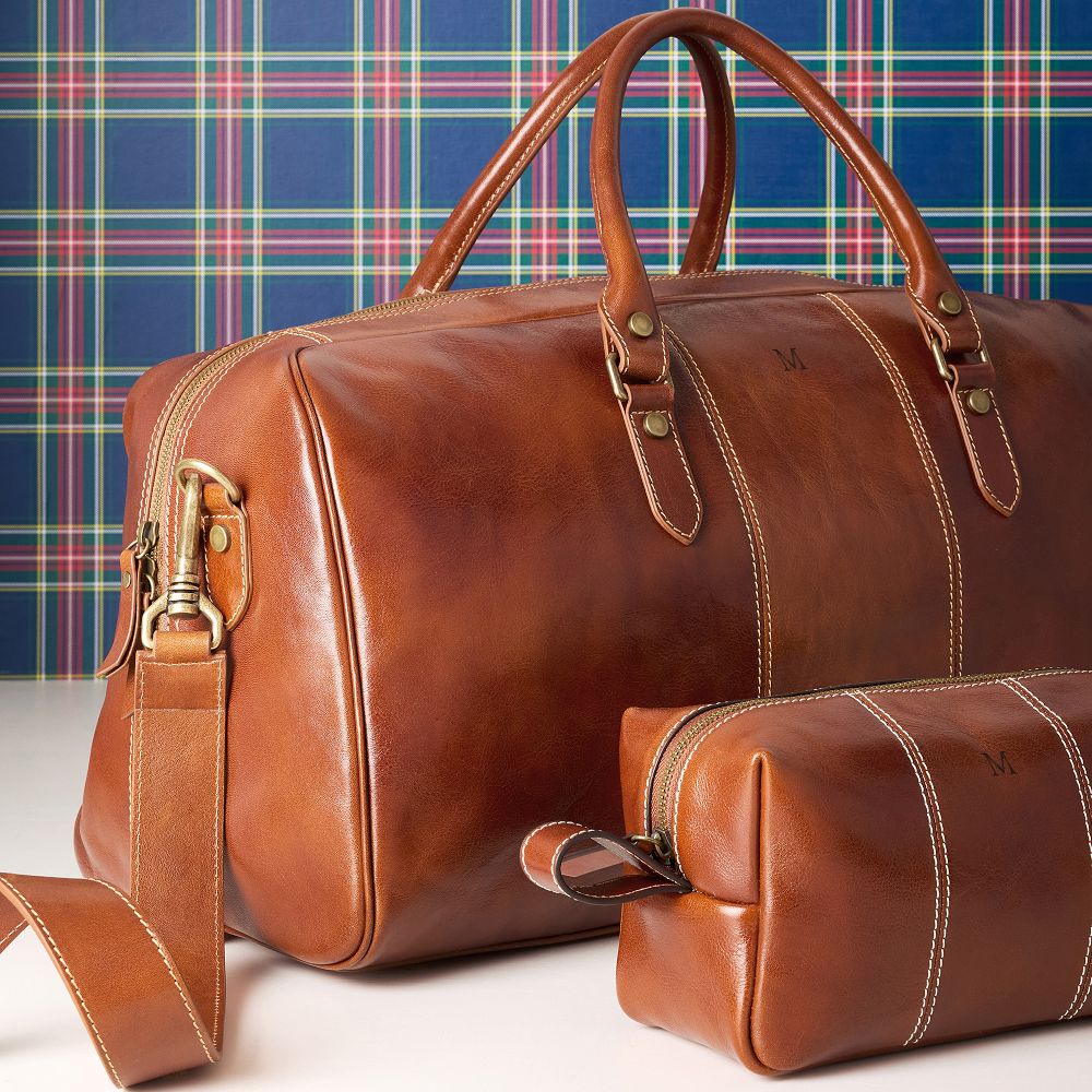 Cognac Marco Italian leather weekender and matching travel pouch against a plaid background